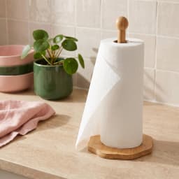 Single light brown wood paper towel holder with an irregular hexagonal base and a round finial on a white background. - view 1