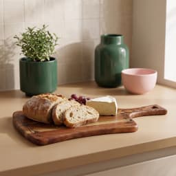 Rectangular acacia wood cutting board with a handle and black floral etching on a white background - view 4