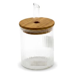 Clear ribbed glass oil dispenser bottle with a light wood lid and a clear glass spout, filled with yellow olive oil, on a wh… - view 3