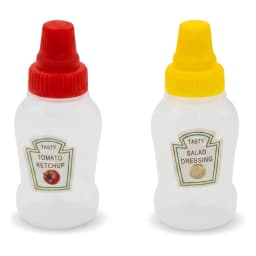 Two translucent white plastic squeeze bottles with red and yellow caps, labeled for ketchup and salad dressing, on a kitchen… - view 2