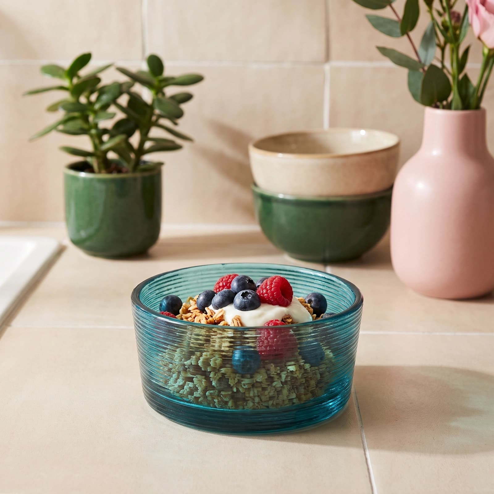 Round teal ribbed glass serving bowl on a white background, showing textured horizontal lines on the exterior.