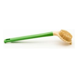 Green and beige silicone back scrubber with a long handle lying on a light countertop with plants in the background. - view 3