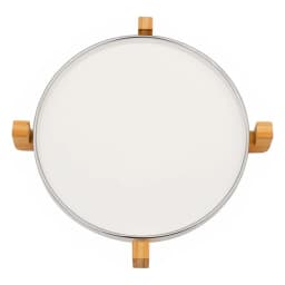 Round white porcelain serving tray with light wood stand on a kitchen counter, holding a small jar and a woven item. - view 2