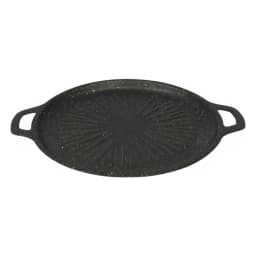 Black round cast iron grill pan with ribbed surface, cooking meat and vegetables on a light kitchen counter. - view 3