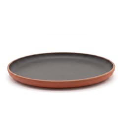 Round melamine plate with a dark grey/black matte surface and a terracotta brown rim, on a white background. - view 3