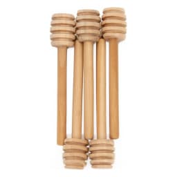 Five light brown wooden honey dippers with spiral grooves, standing upright against a white background. - view 2