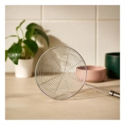 Silver metal skimmer with a round fine mesh head and a long cylindrical metal handle on a white background. - view 4