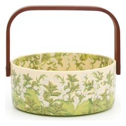 Round glass serving basket with a cream interior and green floral pattern on the exterior, featuring a brown wooden handle. - view 2