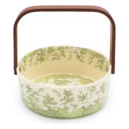Round glass serving basket with a cream interior and green floral pattern on the exterior, featuring a brown wooden handle. - view 3