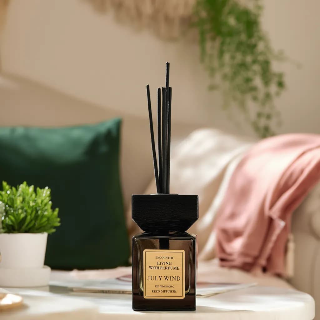 Square dark brown glass reed diffuser with black wooden cap and black reeds on a white background.