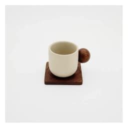 Cream ceramic cup with a round dark wood handle, sitting on a square dark wood coaster, on a white background. - view 2