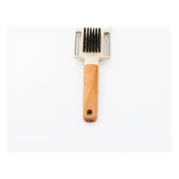 White plastic and wood handle vegetable peeler and scrubber with black bristles, surrounded by fresh carrots and potatoes on… - view 2