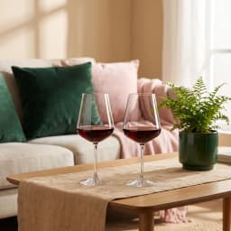 One clear glass wine glass standing next to its brown cardboard box with wine glass illustration and '2 pcs' label on a whit… - view 1