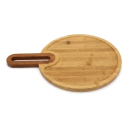 Light brown round bamboo wood cutting board with an integrated rectangular handle, viewed at an angle on a white background. - view 2