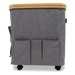 Grey fabric storage hamper with a light brown bamboo wood lid and three front pockets, on wheels. - view 3