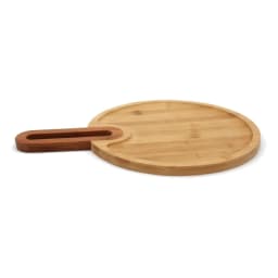 Light brown round bamboo wood cutting board with an integrated rectangular handle on a white background. - view 3