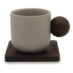 Cream ceramic cup with a round dark wood handle, sitting on a square dark wood coaster, on a white background. - view 3